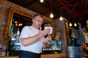 Bartender at the Bar Cleaning a Glass.
