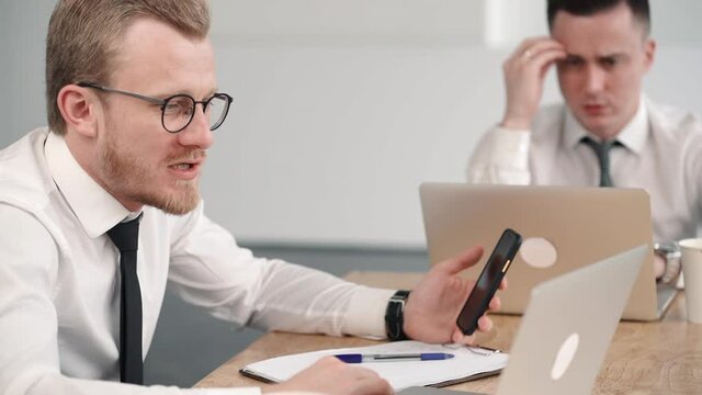 businessmen discuss taxes in office work at laptop. hesitating concerned colleague talking about project. concept communication, coworking, employee. manager with phone writing report