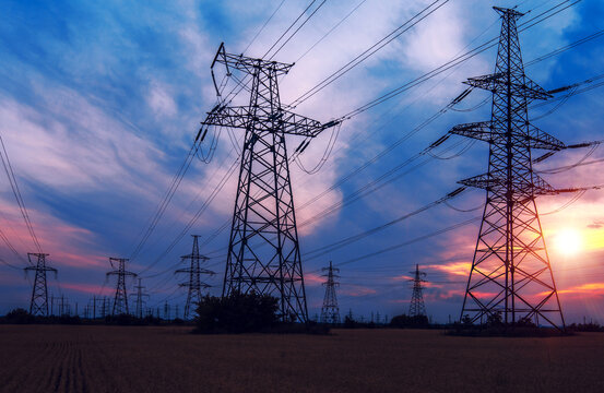  high-voltage power lines at sunset. greeb field.