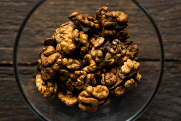 Walnut in a small plate on a vintage wooden table. Walnuts is a healthy vegetarian protein nutritious food. Natural nuts snacks.