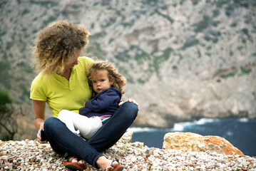 Portrait of a mother with her daughter on the mountain landscape background