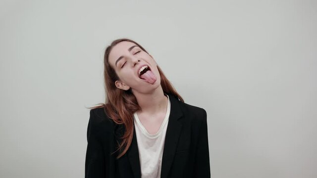 Fooling around outside, sticks out tongue as a sign of disobedience, protest and disrespect. Human emotions, reactions, feelings, attitude, having fun, grimacing healthy oral cavity. Attractive woman