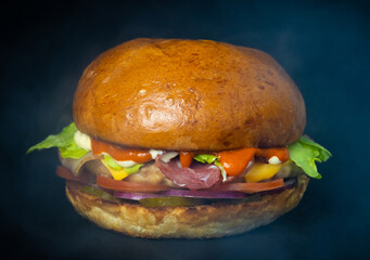 Chicken burger with cheese sauce on a black background