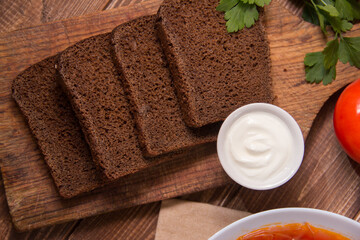 sliced ​​brown bread on wooden background close-up