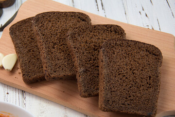 sliced ​​brown bread on wooden background close-up