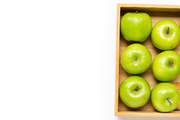 Ripe green apples in wooden box on white background.