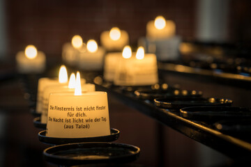 candles in a church with christian writing