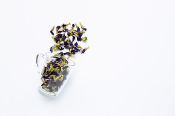 Sun dried butterfly pea with glass cup on white background.