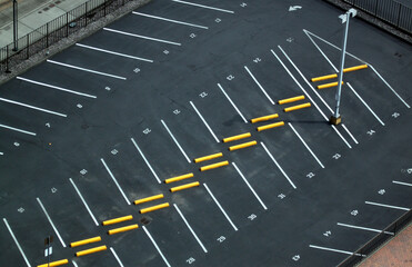 Abstract aerial shots of parking lot with white and yellow stripes and signs