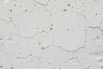 The texture of concrete, an old white wall with irregularities, cracks and potholes. Abstract background.