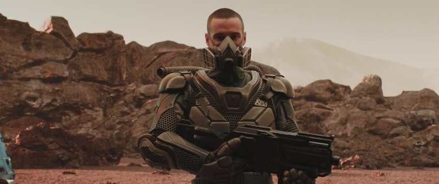 Caucasian male star trooper soldier posing with a gun on a hostile planet, space colonization concept