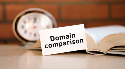 Domain comparison concept text on a white background with a clock and an open book