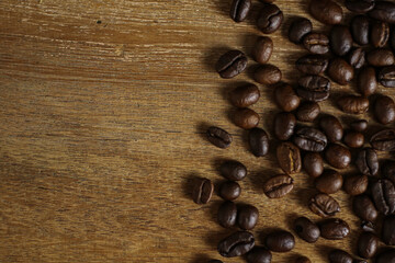 Coffee beans on wooden table with copyspace for text. Selective focus.