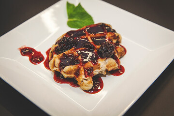 waffle with berries topping on white plate