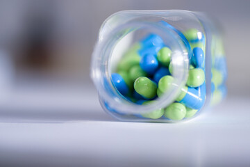 blue and green capsules in a glass