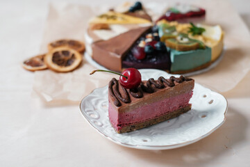 Homemade cake with cherry on parchment paper. Food delivery. Homemade baking. Top view. Delicious tart with chocolate and cherry on the wooden table close-up