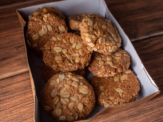 box of homemade oatmeal cookies on a wooden board close-up