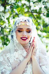 young pretty indian girl in jewelry and veil posing cheerful happy smiling in green park, lifestyle people concept