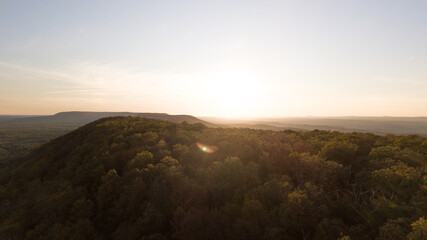 Drone shot of Delaware water gap PA river national park during summer fall foliage with sunset glare on a side of a mountain 