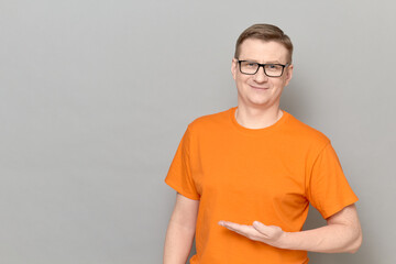 Portrait of happy man pointing with one hand at copy space and smiling