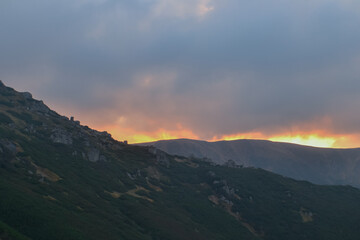 Beautiful sunset view of rock landscape of mountains, forest and meadows in the Carpathians in sunny  cloudy weather