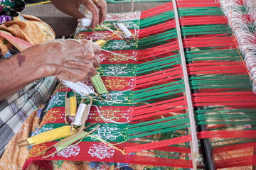 traditionally makes yarn with a spindle wheel at traditional Sasak village, Desa Sasak Sade, Lombok Indonesia.