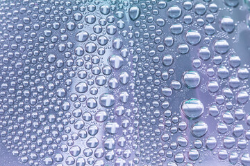 Close up water drops on lilac tone background. Abstract lilac wet texture with water drops on glass...