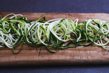 simple food ingredients, zucchini noodles on wooden cutting board