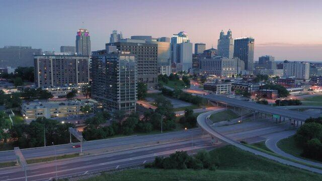 Aerial flying over downtown Kansas City and freeway traffic at sunset. Missouri, USA