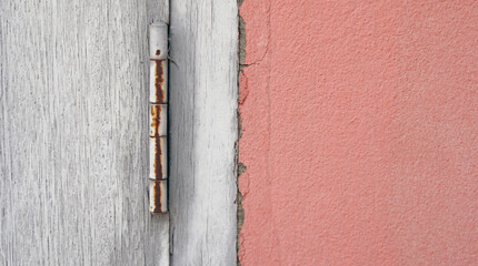Old and dirty vintage wooden door with orange concrete wall, old construction with rust home and design concept. Abstract background.