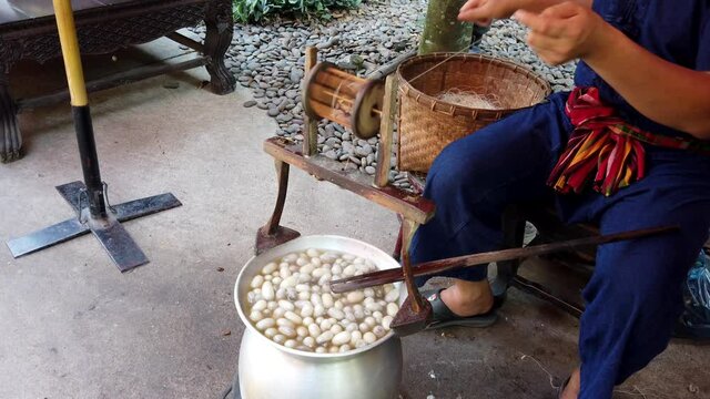 Man Spins Silk Thread From Raw Silk Sacks in Hot Water.