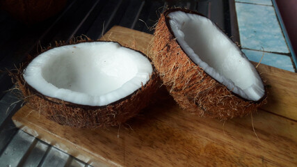 Two coconut half on the chopping plank.Fresh coconut half ready to grind.