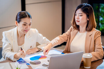 Team work process. Two women with laptop in open space office. Business concept., two women is meeting for business matching. ,Two young beautiful asian business woman in the conversation.