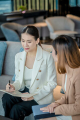 Team work process. Two women with laptop in open space office. Business concept., two women is meeting for business matching. ,Two young beautiful asian business woman in the conversation.