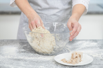 Female hands making dough in the kitchen at home