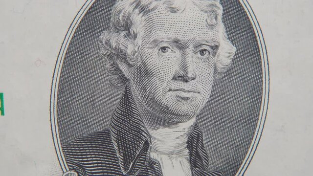 Slow Rotating Thomas Jefferson Face on Two Dollar Bill in Macro. Background with money american bills. Banknotes, cash money background. Rotation paper money close-up. Corporate videos, commercials.