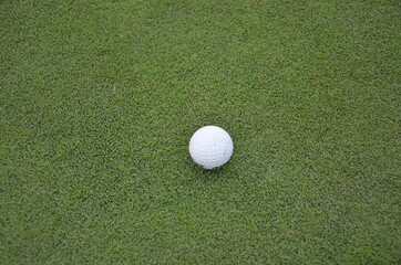 White golf ball on green grass in golf course.  sports outdoor in summer vacation