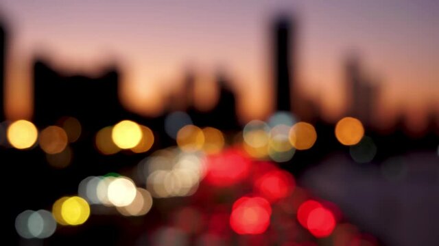 Beautiful glittering bokeh in dark blurry background at night. The round colorful bokeh shine from car lights in traffic jam on city street. Out of focus with blurry. Unfocused city lights. Traffic.