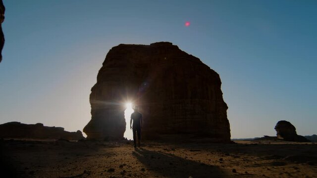 Elephant Rock silhouette shot with figure walking into lens flare, shot on RED Helium 8K with 18mm lens