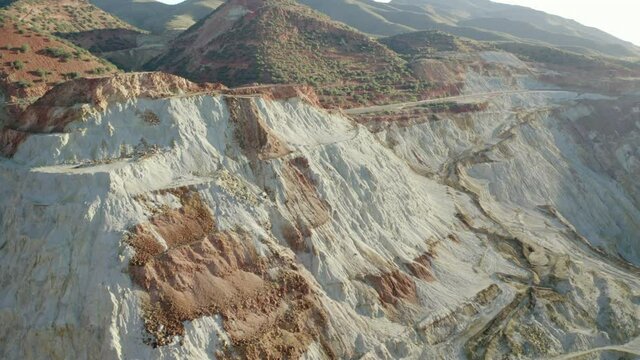 Aerial shot of abandoned open-pit mine on sunny day, drone flying forward over copper quarry - Bisbee, Arizona