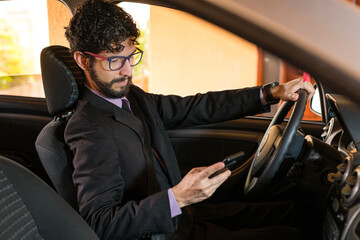 Business man checking cell phone in his car