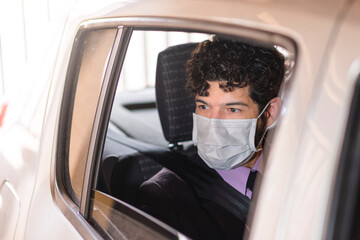 Businessperson using protective mask in car service.