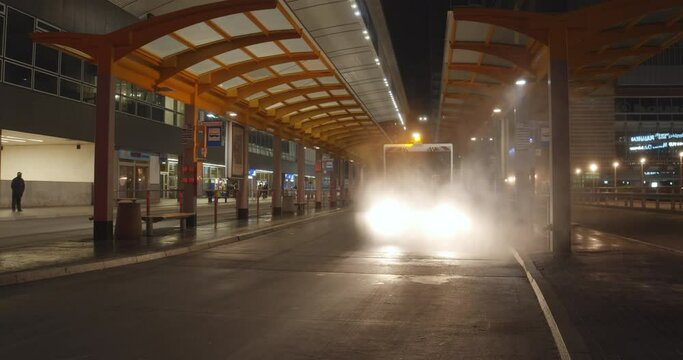 Machine sprayer is disinfecting large bus terminal at night during the covid-19 pandemic