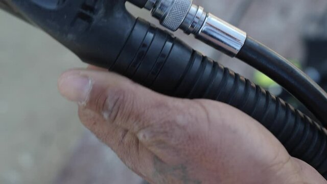 Close-up of connecting the low pressure inflator hose to the BCD while preparing scuba diving equipment.