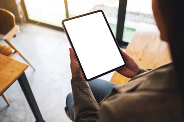 Top view mockup image of a woman holding black tablet pc with blank white desktop screen