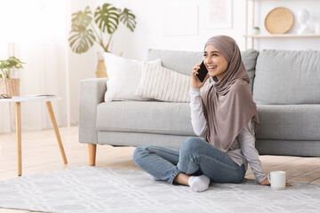 Free Time. Joyful Muslim Girl Talking On Cellphone With Friend At Home