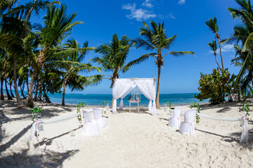 Colorful wedding arch gazebo pavilion made of bamboo and textile with fresh flowers decoration at...