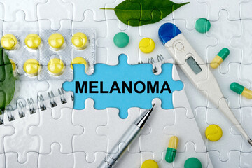 Double exposure. Puzzles with the image of tablets, a notebook, a thermometer and a pen with the inscription -MELANOMA