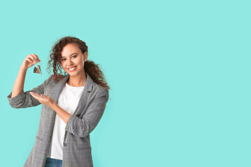 Happy young woman with key on color background