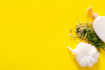 Shower gel with bast wisp and chamomile flowers on color background